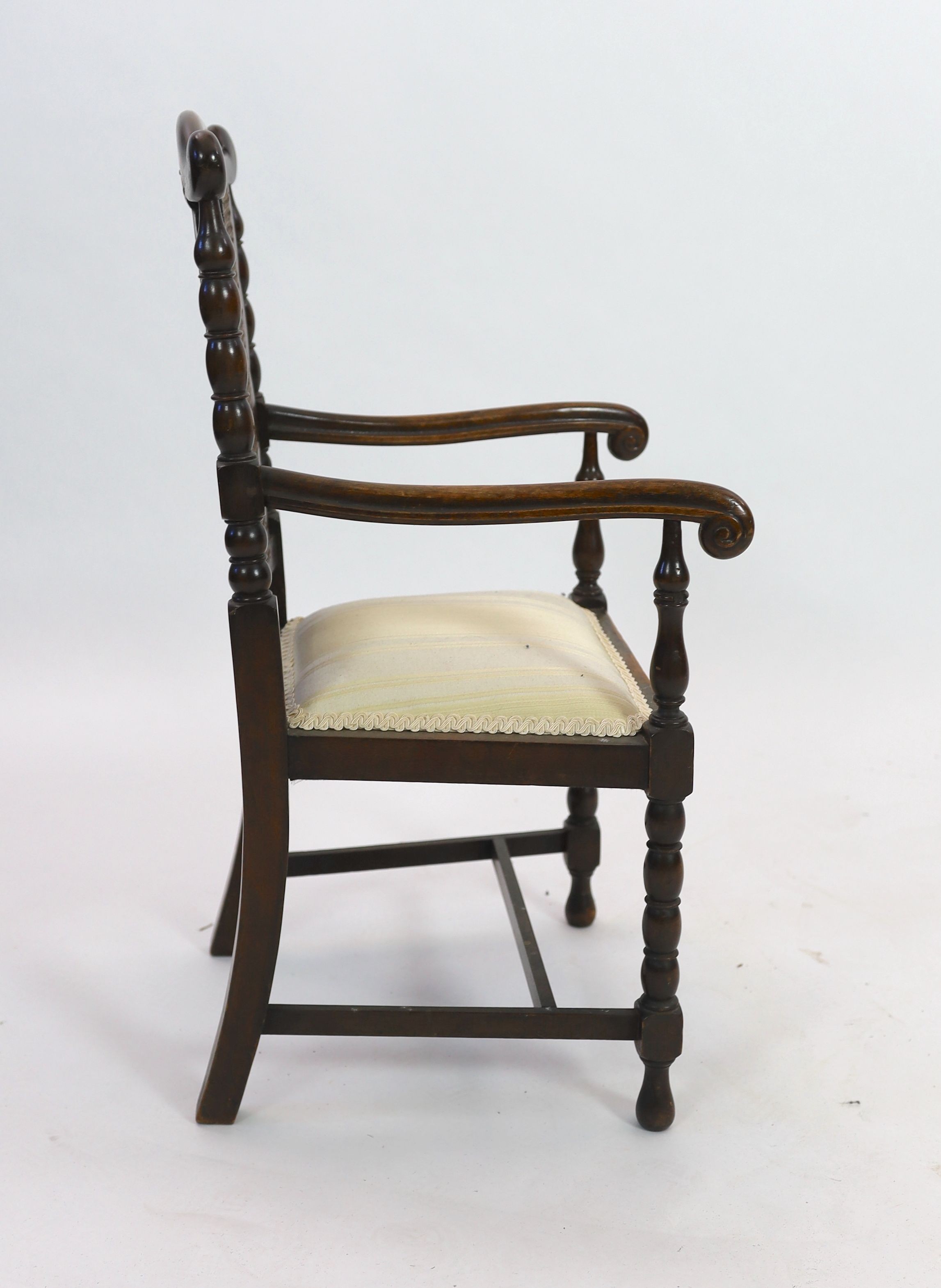 An early 20th century caned beech child's elbow chair